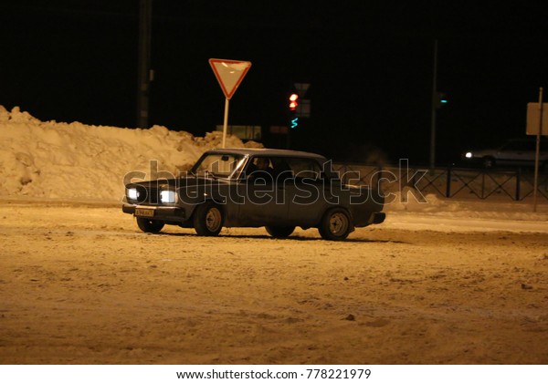 YOSHKAR-OLA, RUSSIA - DECEMBER\
12, 2017: Training in guided drifts on snow, ice and snowdrifts\
into snowfall,  drift on the rear-drive car-on an empty car park in\
the city