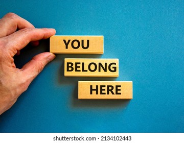 You belong here symbol. Concept words You belong here on beautiful blue table blue background. Businessman hand. Diversity, business, inclusion and belonging concept. You belong here quote. - Shutterstock ID 2134102443