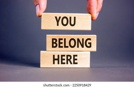 You belong here symbol. Wooden blocks with words 'You belong here' on beautiful grey background. Male hand. Diversity, business, inclusion and belonging concept. - Shutterstock ID 2250918429