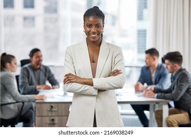 You can call me boss lady. Shot of a young businesswoman standing with her arms crossed in a meeting at work.