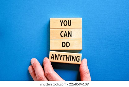 You can do anything symbol. Concept word You can do anything on wooden blocks. Businessman hand. Beautiful blue table blue background. Business and you can do anything concept. Copy space.