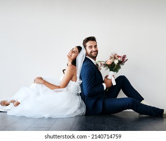 You can lean on me any day. Studio shot of a newly married young couple sitting back to back on the floor against a gray background. - Shutterstock ID 2140714759