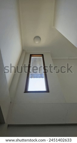 You can see a rectangular glass with white walls and round white lights