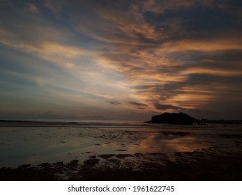 You Can't See Sunset, But You Can See The Sillhouette View Of The Clouds And Small Mountains On The Beach