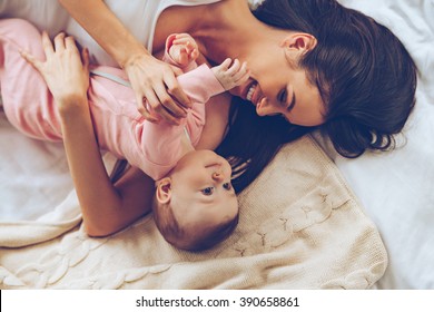 You Do Not Want To Hug With Mommy? Top View Of Cheerful Beautiful Young Woman Hugging Her Baby Girl While Lying In Bed 