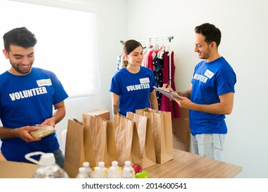 You Are Doing A Good Job. Young Volunteers Working And Doing Community Service While Making Bags With Food For Vulnerable People