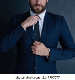 You dont get a second chance at a first impression. Shot of an unidentifiable businessman adjusting his tie against a dark background.