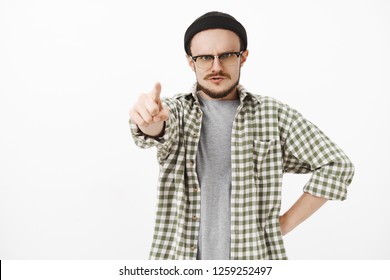 You Guilty. Serious-looking Strict, Irritated Young Male Music Teacher In Black Beanie And Glasses With Moustache Standing In Furious Pose Pointing At Camera Dissatisfied Blaming Student
