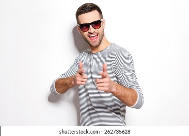 Are You With Me? Handsome Young Man Pointing You And Smiling While Standing Against White Background 