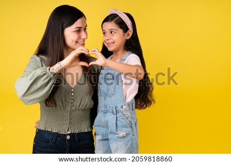 You have all of my heart. Loving mother and cute daughter making a heart gesture together