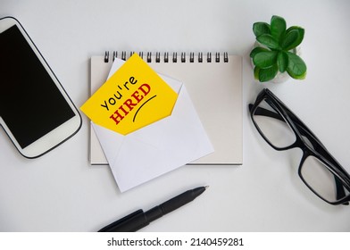 You are hired text on yellow notepad in an envelope. Employment concept - Shutterstock ID 2140459281