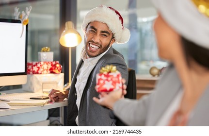 You make Christmas at work extra special. Shot of a young businessman and businesswoman exchanging Christmas gifts in a modern office. - Powered by Shutterstock