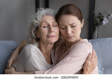 I am with you my baby. Loving mature old female mommy sit on couch embrace tight sad upset grownup kid daughter support comfort. Aged mom encourage beloved adult girl child in difficult life situation - Powered by Shutterstock