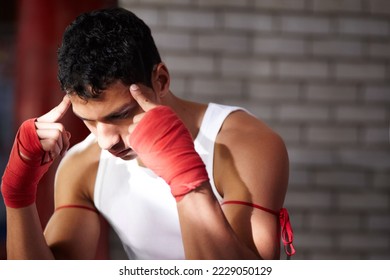 You need to visualise yourself winning. A young fighter mentally preparing before a fight. - Shutterstock ID 2229050129