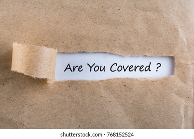 ARE YOU COVERED? Question Message Appearing Behind Ripped Brown Paper. Are You Insured For Your Car, Travel, Home, Health Or Other Liability