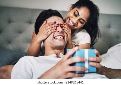 Are You Ready To See What I Got You. Shot Of A Woman Covering Her Boyfriends Eyes While Surprising Him With A Gift.