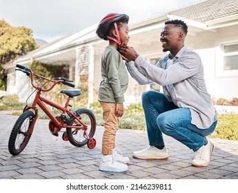 You should be safe while having fun. Shot of a father adjusting a safety helmet on his son while riding a bicycle outdoors. - Powered by Shutterstock