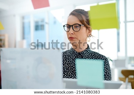 You shouldnt ignore the planning process. Shot of a young businesswoman using a digital tablet while brainstorming with notes on a glass wall in an office.