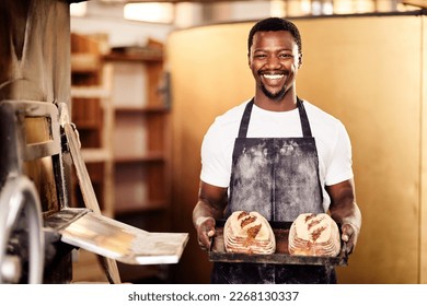 If you want fresh then come to my bakery. Cropped shot of a male baker holding up freshly baked bread in his bakery. - Powered by Shutterstock