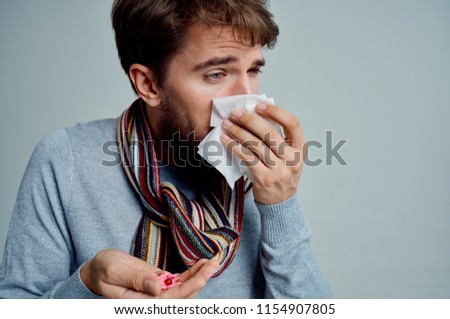 you will catch a cold man with pills in the hands of a cold head scarf around his neck                           