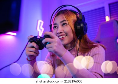 You Win. Gamer Using Joystick Controller Plays Online Video Game With Computer Neon Lights Very Determined, Woman Wear Gaming Headphones Playing Live Stream Esports Games Console At Home