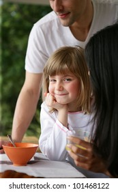 Yougn Family Having Breakfast In The Garden