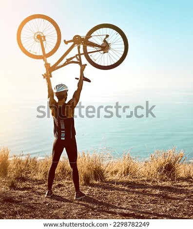 Youll get to the top eventually, keep going. Rearview shot of a male cyclist lifting his mountain bike into the air.