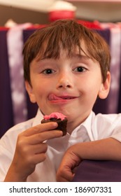 Youn Boy Licking His Lips From Cupcake Frosting