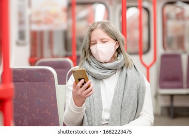 Youn Woman Wearing Protective Mask Against Virus And Air Pollution In Public Transport Uses A Smartphone