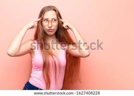 yound blonde woman feeling confused or doubting, concentrating on an idea, thinking hard, looking to copy space on side