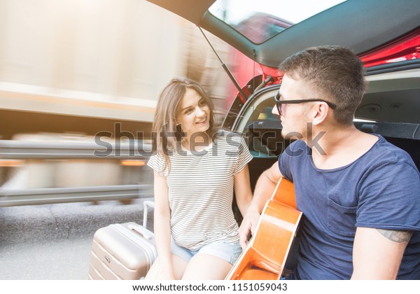 Yound
Couple with suitcases on a trip by car. They sit in the back of the
car, they look at the map, resting after a long drive and having
fun. Hitchhiking and car trips with loved
one