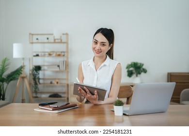 Yound lady working from home using digital tablet in her lovely house.