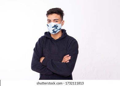 Young 20 Year Old Boy With Personalized Protective Mask On His Face, To Protect Himself From The Coronavirus On White Background, Looking At Camera