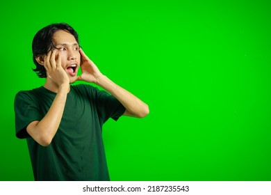 Young 20s South East Asian Man Shouting Expression Isolated Green Background.