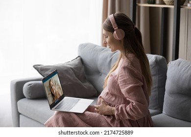 Young 30s Pregnant Woman Sit On Sofa At Home Put Wireless Computer On Laps Makes Videocall Communicates To Little 7s Daughter Living Abroad. Comfort Life Using Modern Technologies, Family Bond Concept