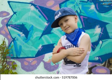 young 5-years boy posing in front of a colorful graffiti wall. Teenager boy dancing hip hop over textured background