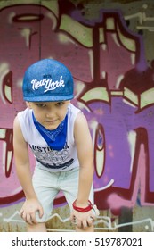 young 5-years boy posing in front of a colorful graffiti wall. Teenager boy dancing hip hop over textured background