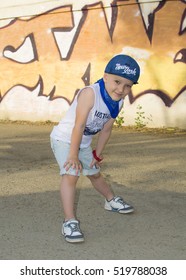 young 5-years boy posing in front of a colorful graffiti wall. Teenager boy dancing hip hop over textured background