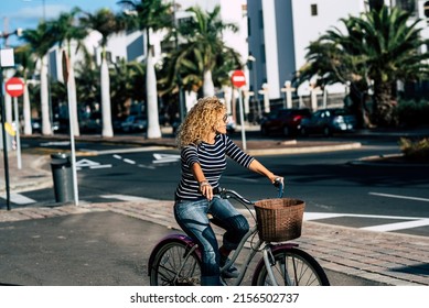 Young Active Adult Woman Use Bike And Take A Ride In The Town. People And Outdoor Leisure Activity. Green Transport Alternative With Bycicle. Modern Female Use And Ride A Bike In The Street