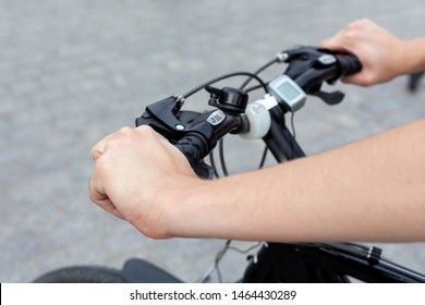 Young Active Man On A Bike Resting His Hands On The Handle Bars, Concrete Background. Speedometer And Led Lighting Equipment Accessories Shown. Outdoor Cycling Activity, Urban Biking Trip Concept