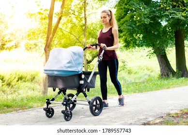 Young active mother is doing sport while walking with stroller