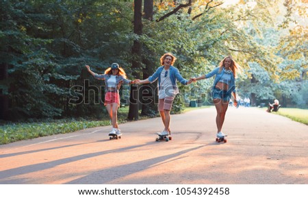 Similar – Happy young woman riding on skate with her friends