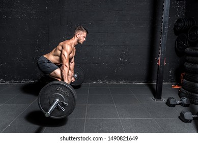 Young active strong fit muscular sweaty man with big muscles doing barbell weight dead lifting cross training workout in the gym dark image real people exercising - Powered by Shutterstock