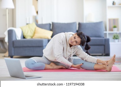 Young Active Woman Repeating After Trainer While Watching Online Workout At Leisure