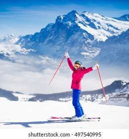 Young Active Woman Skiing In Mountains. Female Skier Kid With Safety Helmet, Goggles And Poles Enjoying Sunny Winter Day In Swiss Alps. Ski Race For Adults. Winter And Snow Sport In Alpine Resort.