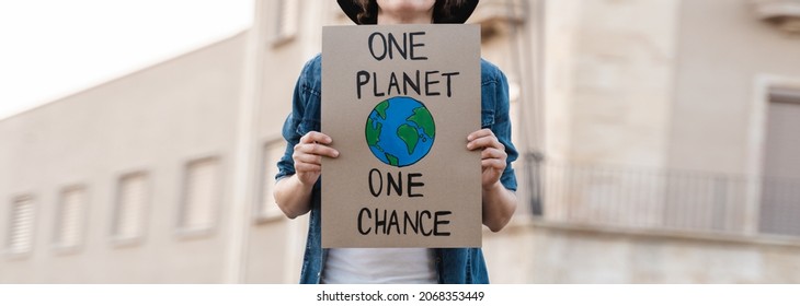 Young activist marching and protest for climate change holding banner - Demonstration for Ecology and environment concept - Shutterstock ID 2068353449