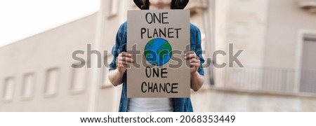 Young activist marching and protest for climate change holding banner - Demonstration for Ecology and environment concept