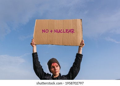 Young activist woman holding a poster against nuclear power and sewage dumping. there is no planet B.