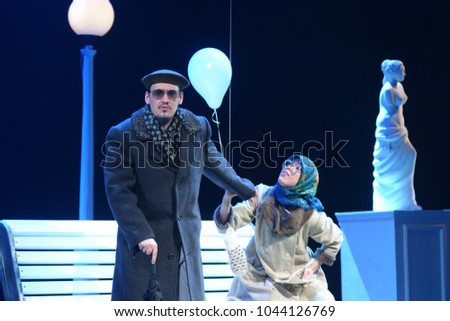 A young actor and actress in makeup sit on a bench on the stage of the theater
