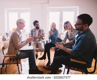 Young Addicted People Having Celebrating Situation While Sitting Together On Special Group Therapy. Brave Persistent Guy Getting Applause After His Confession And Progress.